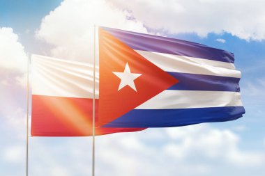 Sunny blue sky and flags of cuba and poland