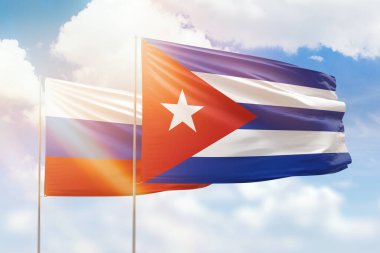 Sunny blue sky and flags of cuba and russia