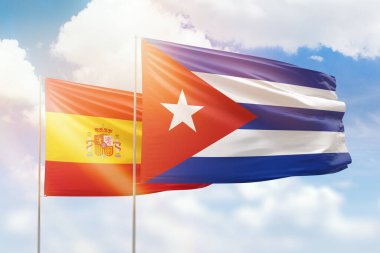 Sunny blue sky and flags of cuba and spain