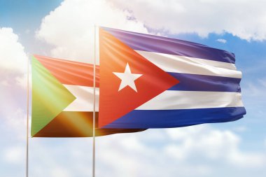 Sunny blue sky and flags of cuba and sudan