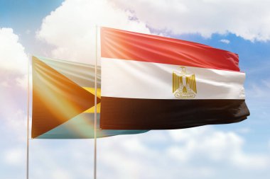 Sunny blue sky and flags of egypt and bahamas