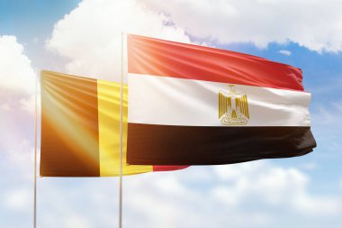 Sunny blue sky and flags of egypt and belgium
