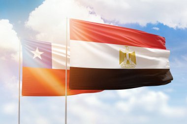 Sunny blue sky and flags of egypt and chile