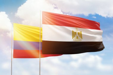 Sunny blue sky and flags of egypt and colombia
