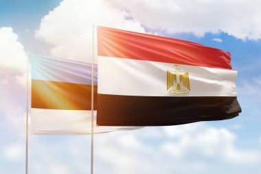 Sunny blue sky and flags of egypt and estonia