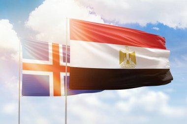 Sunny blue sky and flags of egypt and iceland