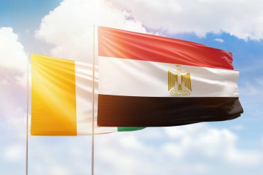 Sunny blue sky and flags of egypt and ivory coast