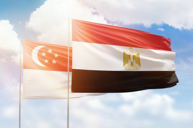 Sunny blue sky and flags of egypt and singapore