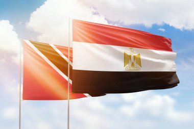 Sunny blue sky and flags of egypt and trinidad and tobago