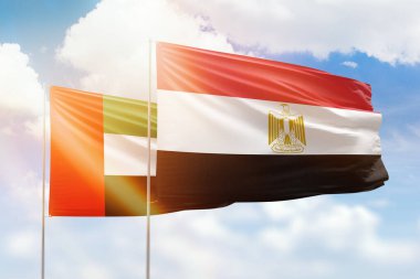Sunny blue sky and flags of egypt and uae