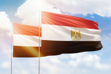 Sunny blue sky and flags of egypt and yemen