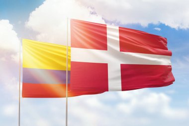 Sunny blue sky and flags of denmark and colombia