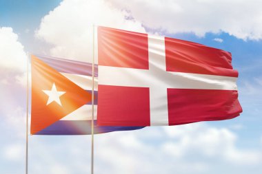 Sunny blue sky and flags of denmark and cuba