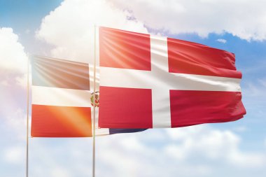 Sunny blue sky and flags of denmark and dominican republic