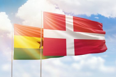 Sunny blue sky and flags of denmark and ghana