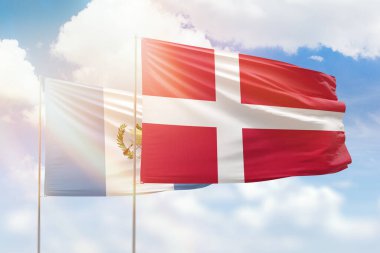 Sunny blue sky and flags of denmark and guatemala