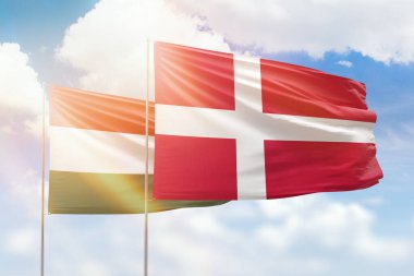 Sunny blue sky and flags of denmark and hungary