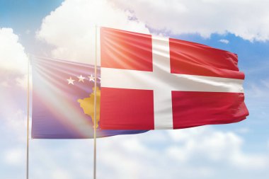 Sunny blue sky and flags of denmark and kosovo