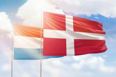 Sunny blue sky and flags of denmark and luxembourg