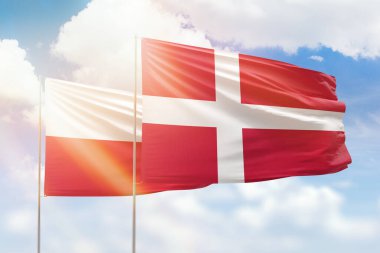 Sunny blue sky and flags of denmark and poland