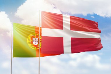 Sunny blue sky and flags of denmark and portugal