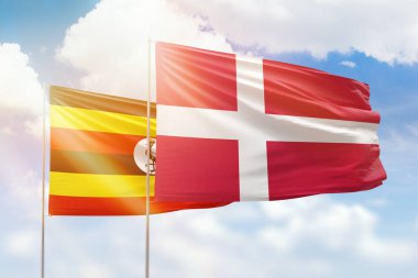 Sunny blue sky and flags of denmark and uganda