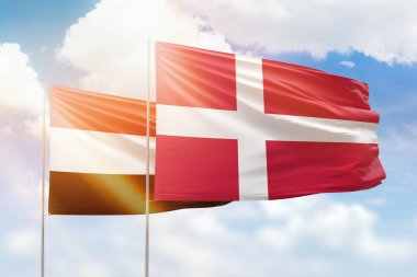 Sunny blue sky and flags of denmark and yemen