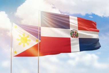 Sunny blue sky and flags of dominican republic and philippines