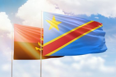 Sunny blue sky and flags of dr congo and angola