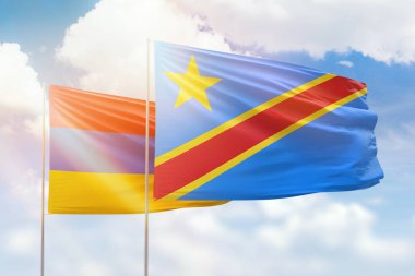 Sunny blue sky and flags of dr congo and armenia