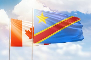 Sunny blue sky and flags of dr congo and canada