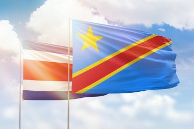 Sunny blue sky and flags of dr congo and costa rica