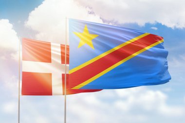 Sunny blue sky and flags of dr congo and denmark