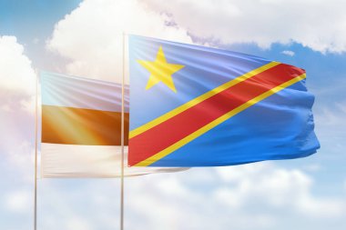 Sunny blue sky and flags of dr congo and estonia