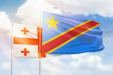 Sunny blue sky and flags of dr congo and georgia