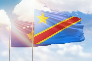 Sunny blue sky and flags of dr congo and kosovo
