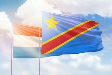 Sunny blue sky and flags of dr congo and luxembourg
