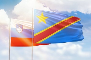 Sunny blue sky and flags of dr congo and slovenia