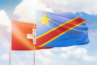 Sunny blue sky and flags of dr congo and switzerland