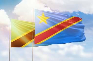 Sunny blue sky and flags of dr congo and tanzania