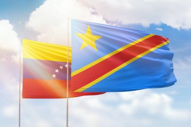 Sunny blue sky and flags of dr congo and venezuela