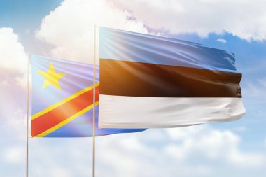 Sunny blue sky and flags of estonia and dr congo