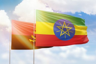Sunny blue sky and flags of ethiopia and angola