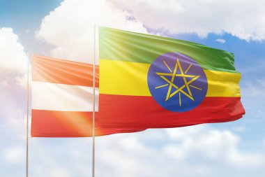 Sunny blue sky and flags of ethiopia and austria