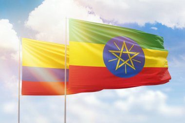 Sunny blue sky and flags of ethiopia and colombia