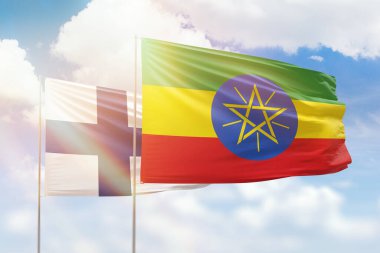 Sunny blue sky and flags of ethiopia and finland