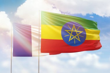 Sunny blue sky and flags of ethiopia and france