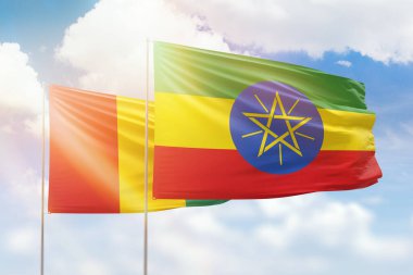 Sunny blue sky and flags of ethiopia and guinea
