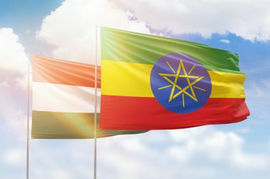 Sunny blue sky and flags of ethiopia and hungary
