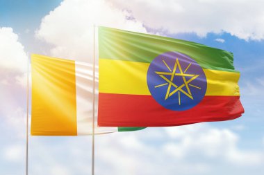 Sunny blue sky and flags of ethiopia and ivory coast